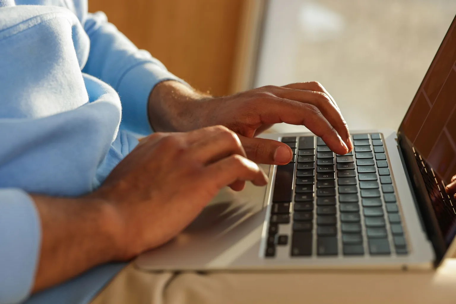Mains tapant sur le clavier d'un ordinateur portable gris