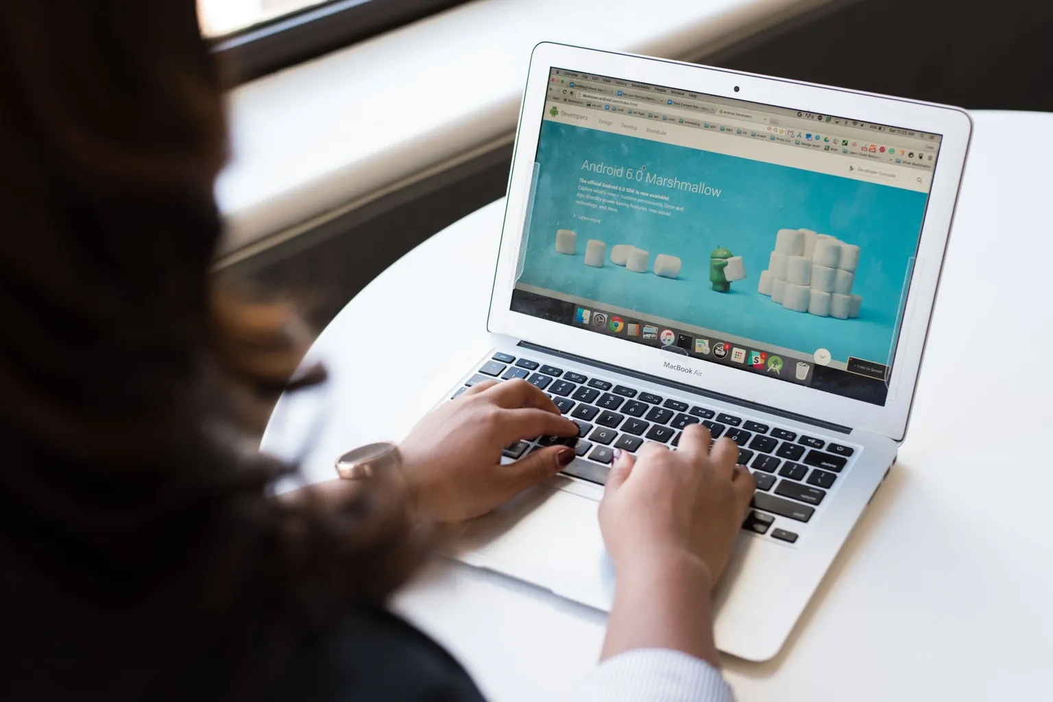 Mains sur le clavier d'un ordinateur portable affichant une page web dans un navigateur